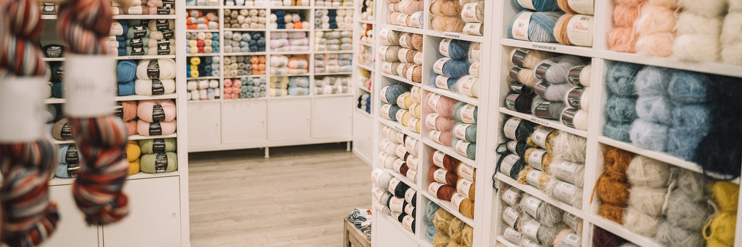 Étagères remplies de laines à l'intérieur de la boutique Phildar café-tricot